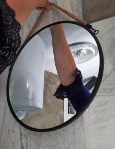 una mujer sosteniendo un espejo con un gato negro en Apartman Bella Vita en Kolašin