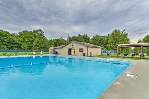 una gran piscina azul frente a una casa en Tranquil Lake Wallenpaupack Home with Fire Pit!, en Lake Ariel