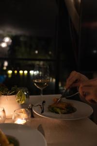 a person eating a plate of food with a glass of wine at Dar Tanja Boutique Hotel in Tangier