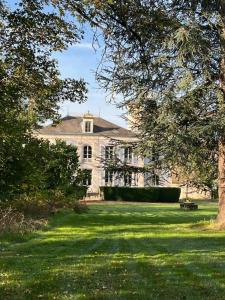 una gran casa blanca con un árbol en el patio en Domaine de Préfond, en Bengy-sur-Craon
