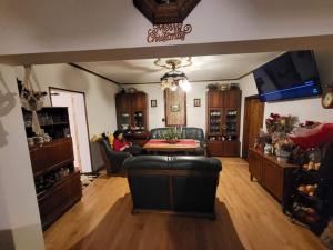 a living room with a woman sitting on a couch at Pensiunea Bradet in Broşteni