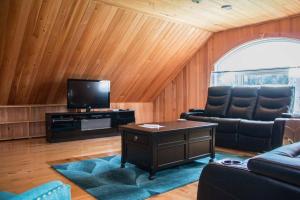 uma sala de estar com um sofá e uma televisão em Villa CARPE DIEM em Sainte-Flavie