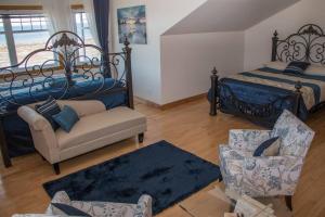 um quarto com uma cama, um sofá e uma cadeira em Villa CARPE DIEM em Sainte-Flavie