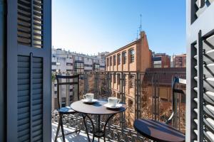 - Balcón con 2 sillas y 2 tazas de café en Majestic 4BR/4BATH apartment in Sagrada Familia area, en Barcelona