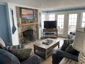 uma sala de estar com lareira e televisão em Nubble Beach House- York Beach Oceanfront w/ Amazing Views em York