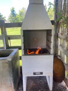 a outdoor grill with a fire in it at Fazenda a 15 min do centro com Rio Particular in Bonito