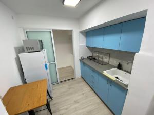 a kitchen with blue cabinets and a white refrigerator at Izhak Aveinu 15 in Beer Sheva