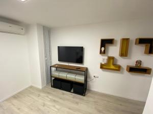 ein Wohnzimmer mit einem TV an der Wand in der Unterkunft Izhak Aveinu 15 in Be’er Scheva