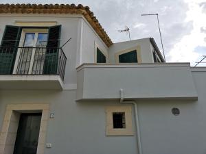 a white building with a balcony on top of it at Fichi e Gelsomino - Casa Vacanze in Donnalucata +125 photos