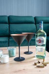 butelkę alkoholu i dwa kieliszki martini na stole. w obiekcie Aquarius Residence - Apartament Jamesa Bonda 007 w Boszkowie
