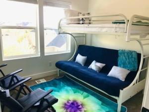 Zimmer mit einem blauen Sofa und Etagenbetten in der Unterkunft Draper Luxury Townhouse in Draper