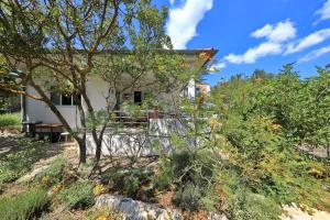 a house on top of a hill with trees at Apartment Justina in Murter