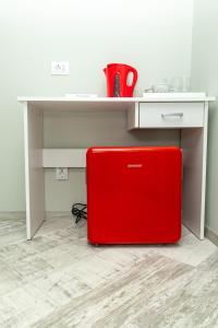 un maletín rojo sentado bajo una mesa en una cocina en EdMont, en Pietroşiţa