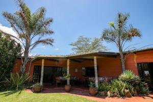a house with palm trees in front of it at Punda Milias Lodge in Nakuru