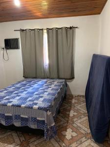 een slaapkamer met een bed en een raam bij Casa Temporada Cabo Frio in São Pedro da Aldeia