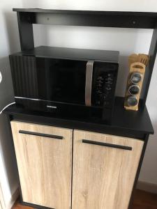 a black microwave sitting on top of a wooden cabinet at Tulle : superbe appartement quartier historique in Tulle