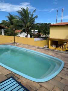 a large blue swimming pool in a yard at Casa Temporada Cabo Frio in São Pedro da Aldeia