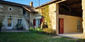 a house with a red door and a yard at la Ferme du Grand Bois in Mouterre-Silly