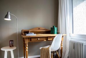 - un bureau en bois avec une chaise blanche à côté d'une fenêtre dans l'établissement GreenHill 4 - mit Privatsauna, à Oberstaufen