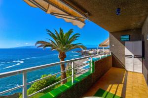 - un balcon avec un palmier et l'océan dans l'établissement Costa Isora, à Puerto de Santiago