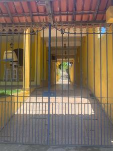 a gate in front of a yellow building at Casa Temporada Cabo Frio in São Pedro da Aldeia