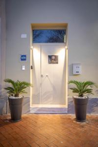 two potted plants sitting in front of a door at Le Stagioni Luxury Suite in Forlì