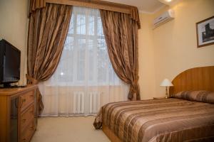 a bedroom with a bed and a large window at Assol Hotel in Taganrog