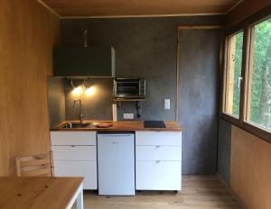 a small kitchen with a white refrigerator and a table at Tiny Häuschen in Ossiach