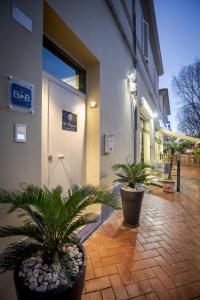 a courtyard with two potted plants in front of a building at Le Stagioni Luxury Suite in Forlì