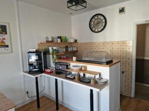 a kitchen with a table with a microwave and a counter at Hôtel du Commerce - Centre Millau in Millau +13 photos