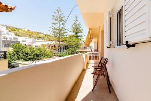 einen Balkon eines Hauses mit zwei Stühlen in der Unterkunft Sea Aura Crete, family seaside house in Agia Pelagia in Agia Pelagia