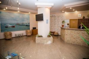 a lobby with a large painting of a boat on the wall at Assol Hotel in Taganrog