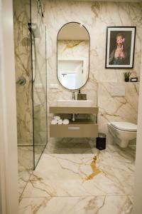 ein Badezimmer mit einem Waschbecken, einem Spiegel und einem WC in der Unterkunft URBAN UNIT - nearby city center in Wien