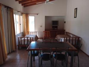 a dining room with tables and chairs and a television at Complejo El Peregrino in Cortaderas