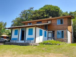 uma pequena casa com persianas azuis em Refúgio da Mata Atlântica Sobrado Centenário em Torres