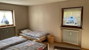 a bedroom with two beds and two windows at Ferienwohnung Panoramablick in Bolsterlang