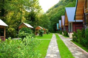 a path through a village with houses and trees at Chalet Rivier • შალე რივიერ in K'eda