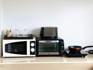 a microwave and a toaster oven sitting on a counter at Phumin Apartment in Ko Lanta