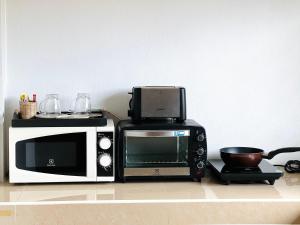 un microondas y un horno tostador en una encimera en Phumin Apartment, en Ko Lanta