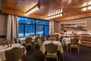 a restaurant with tables and chairs and a large window at Wellness Hotel Šedý Vlk in Harrachov