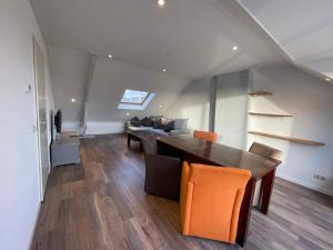 uma sala de jantar com uma mesa de madeira e cadeiras laranja em TopSleep Apartment 26-3 em Arnhem