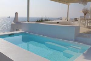 una piscina en una casa con el océano en el fondo en Thea Villas Paros, Villa Turquoise, private pool en Kampos Paros