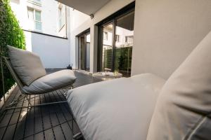 ein Schlafzimmer mit einem Bett und einem Stuhl auf dem Balkon in der Unterkunft URBAN UNIT - nearby city center in Wien