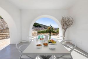 un comedor blanco con una mesa y sillas blancas en Thea Villas Paros, Villa Turquoise, private pool en Kampos Paros