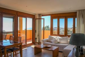 Apartamento Alcocebre Beach Resort في الكوسيبري: غرفة معيشة مع أريكة وطاولة