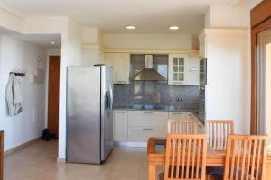 阿爾考斯布里的住宿－Apartamento Alcocebre Beach Resort，厨房配有冰箱和桌椅