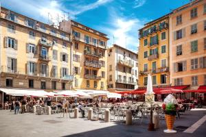 a group of tables and chairs with umbrellas and buildings at St Joseph · Great holiday flat - old town for 4 in Nice