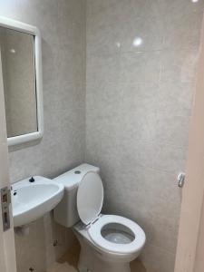 y baño con aseo blanco y lavamanos. en Departamento 2 Ambientes Nuevo La Perla en Mar del Plata