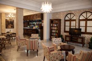 salon z krzesłami i telewizorem oraz bar w obiekcie Arcos de Montemar w mieście Torremolinos