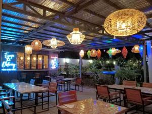 a restaurant with tables and chairs and chandeliers at Urban Oasis Resort, Tarlac in Tarlac